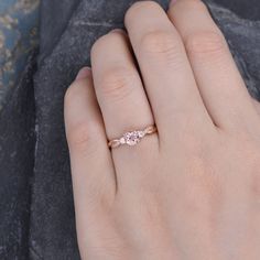 a woman's hand with a diamond ring on top of her left hand,