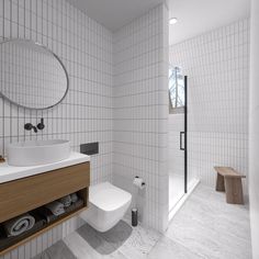 a white tiled bathroom with a sink and toilet