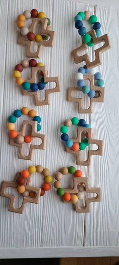 several wooden toys are arranged on a white table top with wood bead pieces in the shape of letters