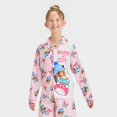 Your kid will stay cozy as they wind down for bed with this Squishmallows 2-Piece Coat Pajama Set in pink. This pack includes a long-sleeve sleep shirt in a front button-down style with allover Squishmallow prints along with the "Warm and Cozy" text plus pajama pants with an elastic waistband and the same Squishmallow prints. Made from jersey fabric, this classic-fit pajama set is a must-have addition to your kid's PJ wardrobe. Cozy Pajamas, Pink M, Pajama Pant, Fabric Tape, Print Pajamas, Kids Outfits Girls, Sleep Shirt, Long Sleeve Pyjamas, Stay Cozy