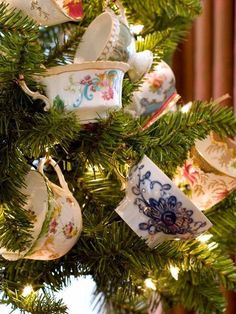 tea cups are hanging from a christmas tree