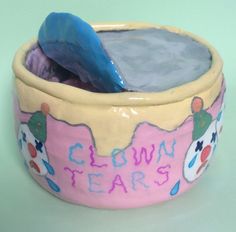 a close up of a bowl with a spoon in it and the words clown tears painted on it