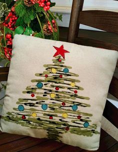 a christmas tree pillow sitting on top of a wooden chair