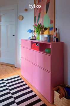 a pink dresser sitting on top of a wooden floor