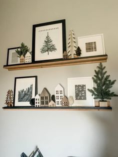 two shelves with pictures and christmas trees on them, one shelf is filled with miniature houses