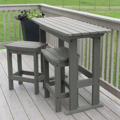 two stools on a deck with a table and potted plant