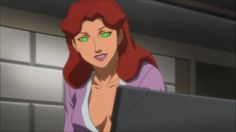 a woman with red hair and green eyes looking at a laptop