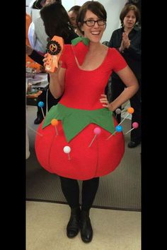 a woman dressed as a strawberry holding a cell phone in her hand and wearing a costume