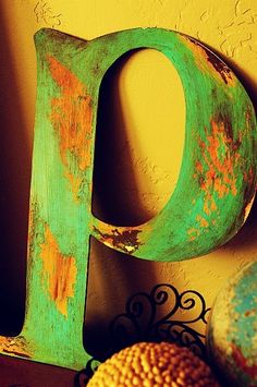 an old green letter sitting on top of a table next to oranges and other items