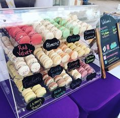 a display case filled with lots of different flavored donuts