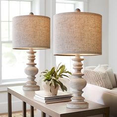 two lamps sitting on top of a table next to a couch