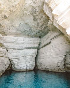 there is a blue pool in the middle of some rocks and water that looks like it has been carved into an ice cave