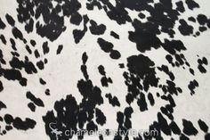 a brown and white cow print rug with a ruler in front of it on the floor