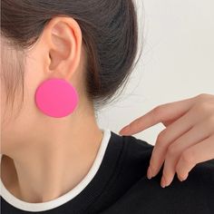 a close up of a person wearing pink earrings