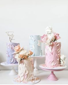 there are three cakes that have flowers on the top and one is blue, pink, and white