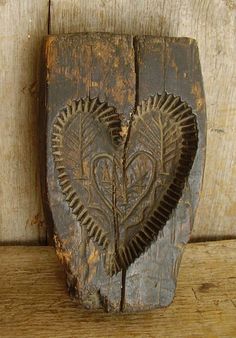 a heart carved into the side of a piece of wood