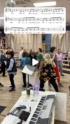 a group of people standing around a musical keyboard