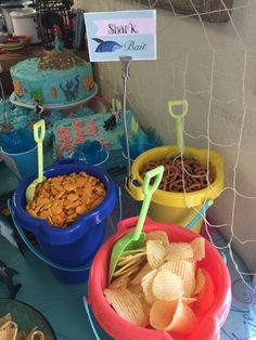 a table topped with bowls filled with different types of snacks and desserts on top of it