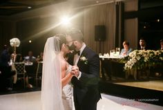 a bride and groom share their first dance at their wedding reception in front of an audience