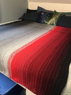 a bed with a red, white and blue blanket on it