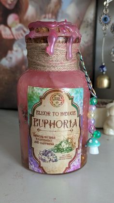 a pink jar filled with liquid sitting on top of a table next to a photo