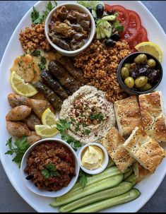 a white plate topped with different types of food and dipping sauces on top of it