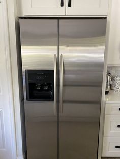 a stainless steel refrigerator in a white kitchen