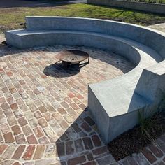 a concrete bench sitting on top of a brick patio