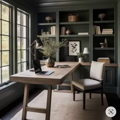 a home office with built - in bookcases, desk and chair by the window