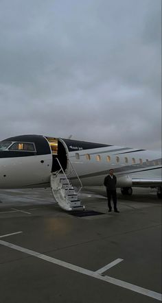 an airplane is parked on the tarmac with stairs leading up to it's door