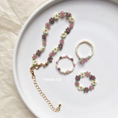 a white plate topped with two bracelets and a necklace