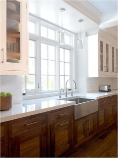 a kitchen with white walls and wooden cabinets, stainless steel sink and dishwasher