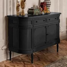 a black sideboard with two golden vases on top