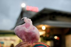 a person holding up a pink cotton floss