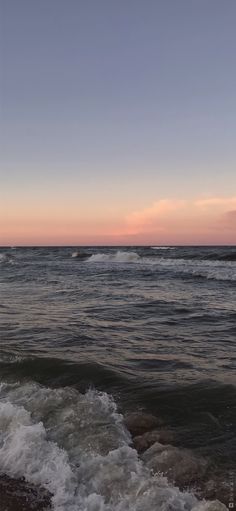 the sun is setting over the ocean with waves