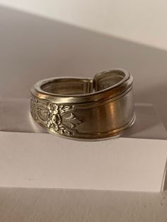 "Handcrafted from a vintage 1847 Rogers Bros silver plated spoon, this ring earns the \"Ambassador\" label through its intricate interwoven symbols representing many nations. Pictured here is a size 11. For other sizings, please ask! We'll try to find you a fit." Antique Silver Ring With Decorative Band, Antique Silver Rings With Decorative Band, Handmade Antique Silver Engraved Ring, Antique Silver Engraved Ring, Unique Stamped Antique Silver Rings, Vintage Adjustable Engraved Etched Ring, Vintage Adjustable Sterling Silver Rings, Vintage Adjustable Engraved Ring, Vintage Silver Engraved Ring As Gift