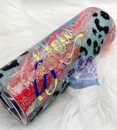 a pink and blue leopard print tumbler with the word hello kitty on it's side