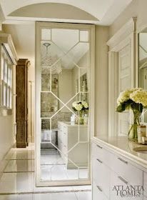 a vase with flowers sitting on top of a counter next to a mirror in a bathroom