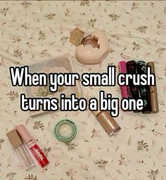 the contents of a purse and cosmetics on a bed with text that reads, when your small crush turns into a big one