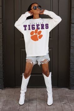 Bring the energy of the game to your wardrobe with our oversized long sleeve tee with ribbed neckline and cuffs. You'll be showing off your Clemson Tigers team spirit in iconic style. White T-shirt With Ribbed Cuffs For College, White Tops With Ribbed Cuffs For Sports Season, White Varsity Top With Ribbed Cuffs, White T-shirt With Ribbed Cuffs For Spring, Oversized Long Sleeve Fan Apparel Tops, College Style Long Sleeve Tops For Sports Season, White Team Spirit T-shirt For Fall, Collegiate White T-shirt For Fall, White Collegiate T-shirt For Fall