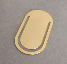 an oval shaped metal object sitting on top of a gray surface with a small hole in the middle