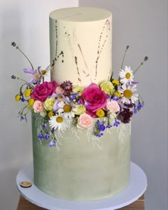 a three tiered cake with flowers on top