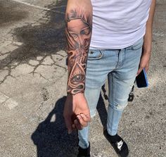 a man with a tattoo on his arm holding the hand of another person