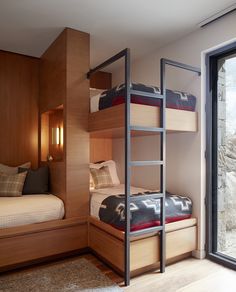 two bunk beds in a bedroom next to a window with sliding glass doors that look out onto the outdoors