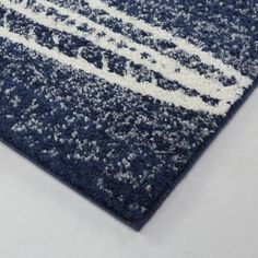 a blue rug with white lines on the top and bottom, is shown in close up