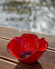 a red bowl sitting on top of a wooden table