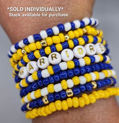 a woman's arm with several bracelets made out of beads and letters on it