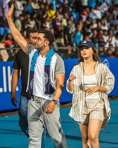 a tennis player waves to the crowd as he walks with his arm in the air