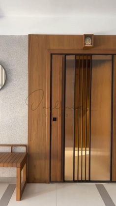 a wooden bench sitting in front of a doorway with glass panels on the doors and sides