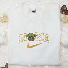 Introducing our adorable Baby Yoda Having Coffee Embroidered Shirt! Made from premium quality fabric, this shirt features a beautifully detailed Disney Tinkerbell Shirt, Starbucks Christmas Cups, Nike Cartoon, Disney Character Shirts, Embroidered Apparel, Mike Wazowski, Frankenstein Halloween, Starbucks Christmas, St Patrick's Day Gifts